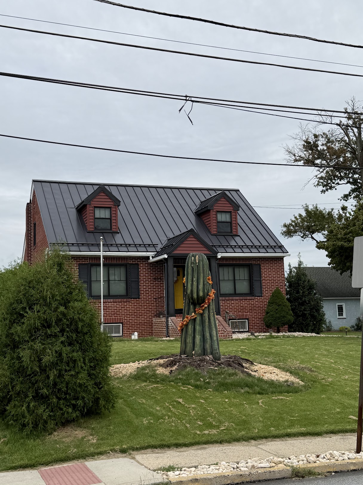 Charcoal metal roof with two dormers on a brick home